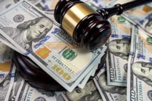 A gavel lying on a pile of cash for a blog post about what happens when you sue someone with no money