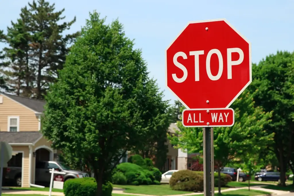 What are the rules of a four-way stop? A stop sign at an intersection in a suburban neighborhood.